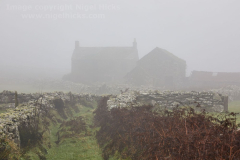 An abandoned farm in fog, on moors at Men-an-Tol prehistoric site, near Penzance, Cornwall, Great Britain.