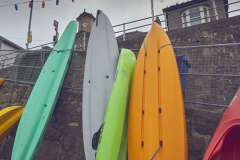 Kayaks in the fishing harbour at Mousehole, near Penzance, Cornwall, Great Britain.