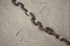 A chain and gull prints in sand in the fishing harbour at Mousehole, near Penzance, Cornwall, Great Britain.